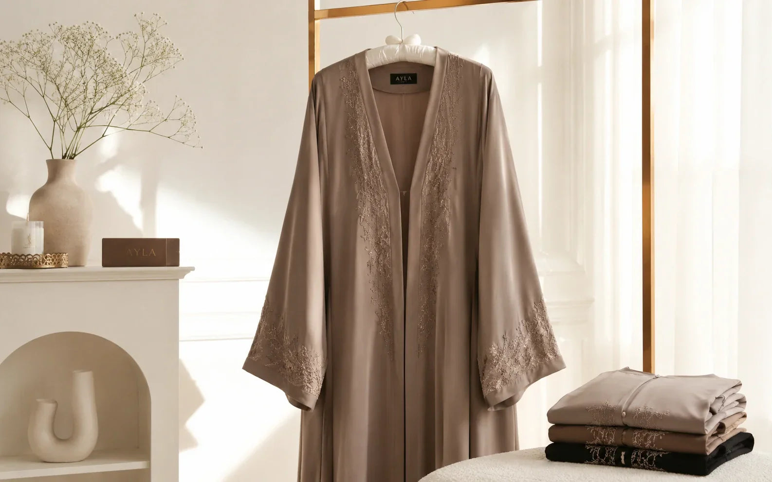Abaya noire soignée suspendue sur un cintre rembourré