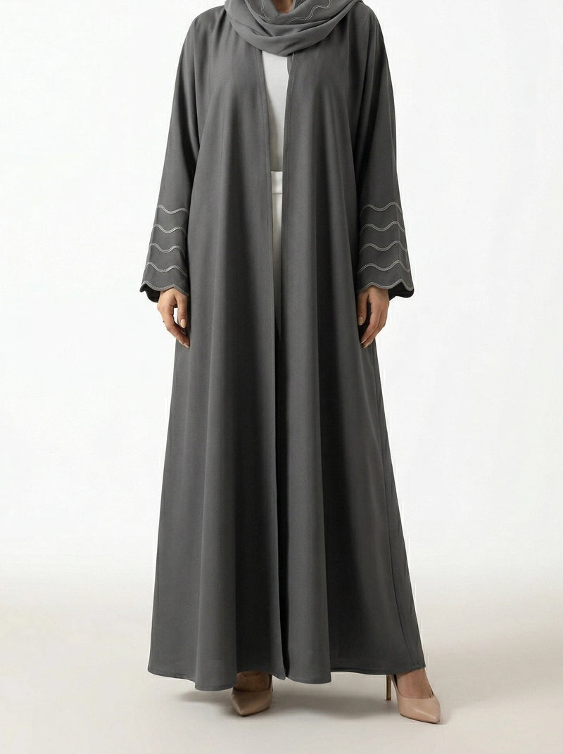 Femme portant l'Abaya Dubai Kimono Lyana gris perle en studio, vue de face sur fond neutre.