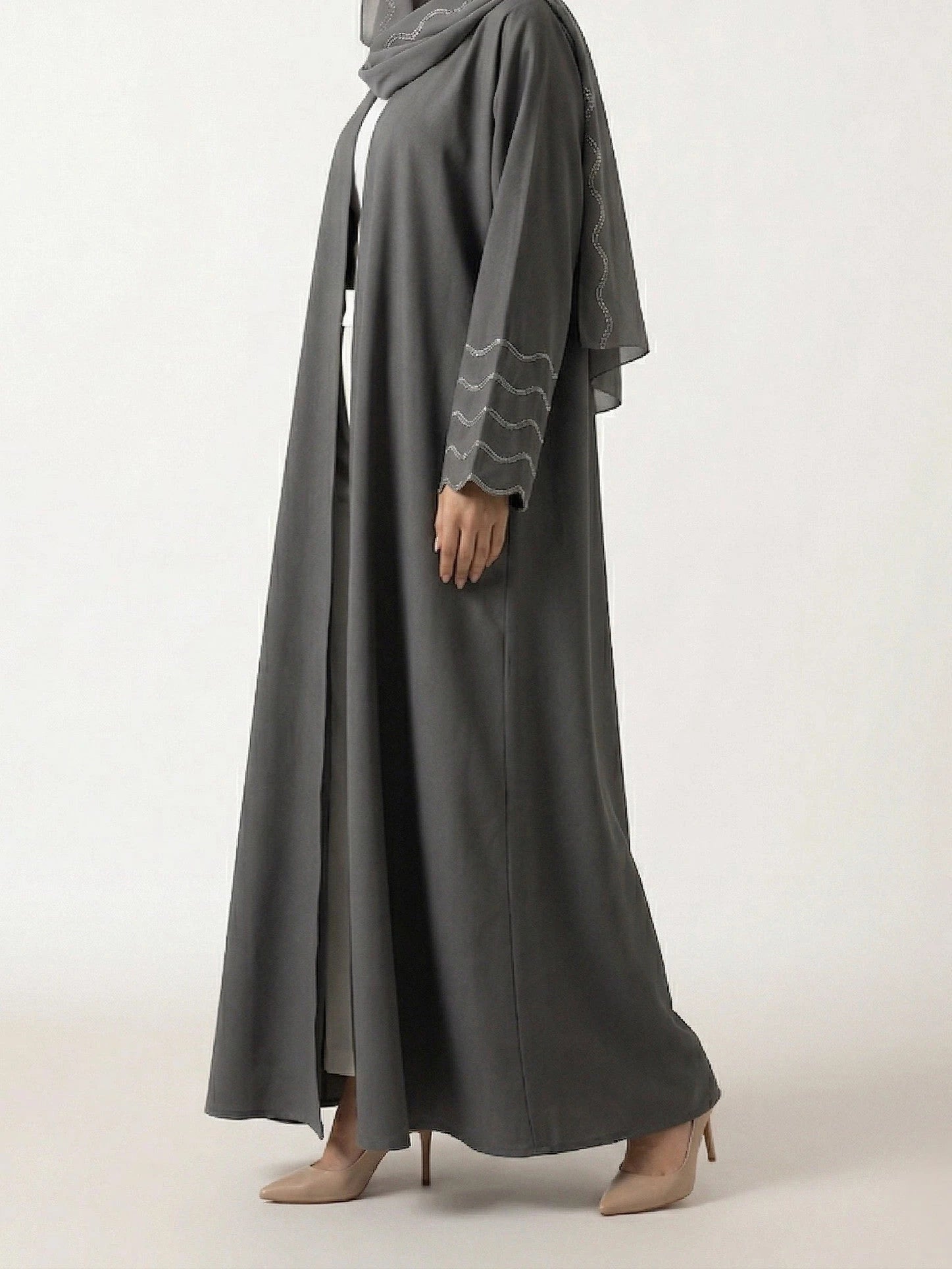 Femme portant l'Abaya Dubai Kimono Lyana gris perle en studio, vue de 3/4 sur fond neutre.